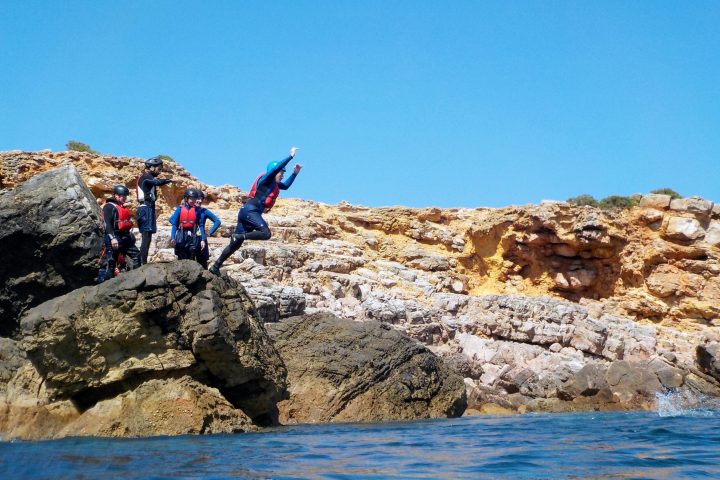 a man flying through the air on a rock